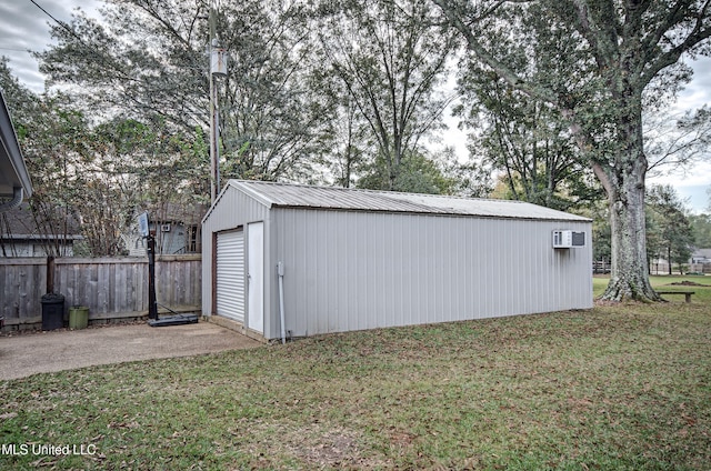 view of outbuilding featuring a lawn and a wall mounted AC