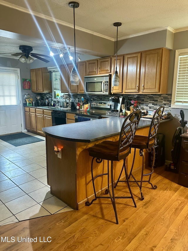 8215 Whitehead Dr, Southaven, MS 38671 - kitchen featuring stainless steel microwave, range with electric stovetop, dark countertops, ornamental molding, and tasteful backsplash