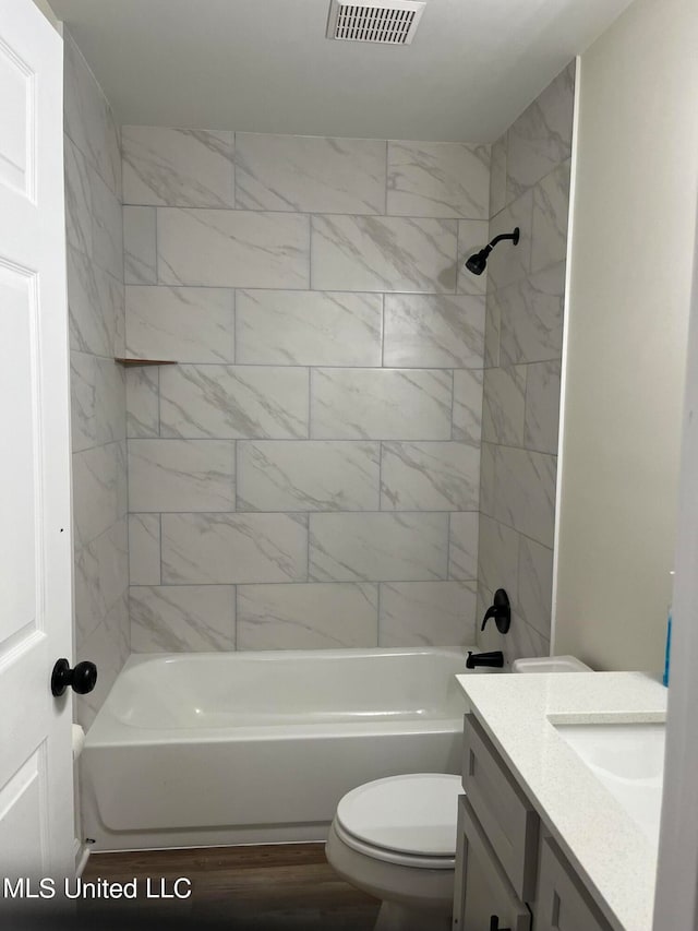 full bathroom with toilet, tiled shower / bath combo, and vanity