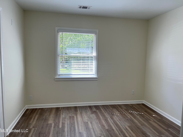 empty room with dark hardwood / wood-style flooring