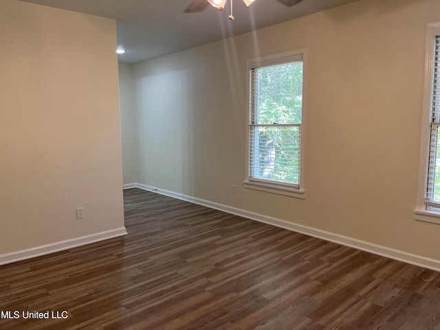 spare room with a healthy amount of sunlight, dark wood-type flooring, and ceiling fan