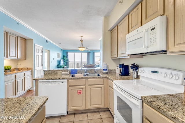 kitchen with light brown cabinets, a peninsula, white appliances, and a sink