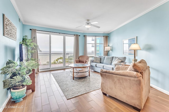 living area featuring visible vents, light wood-style floors, ornamental molding, a ceiling fan, and baseboards