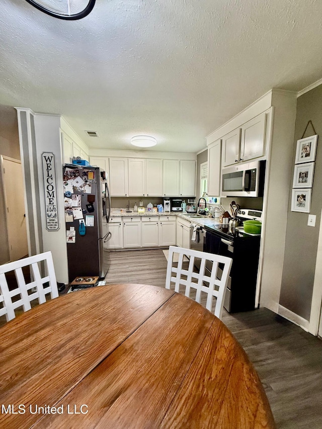 412 Monica Ln, Pearl, MS 39208 - dining room with a textured ceiling and wood finished floors