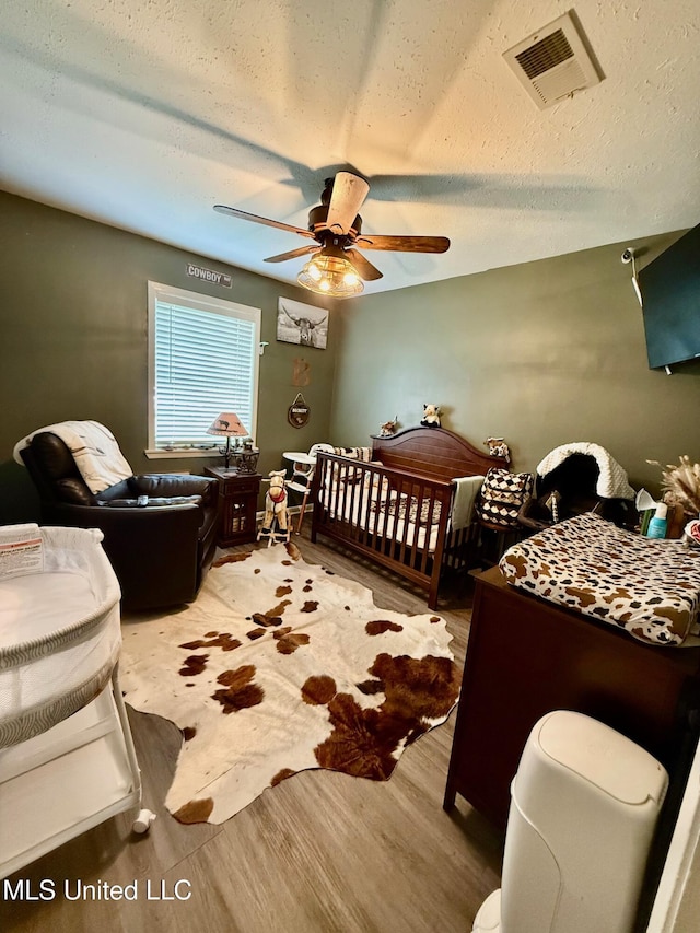 412 Monica Ln, Pearl, MS 39208 - bedroom with light wood-type flooring, a ceiling fan, and a textured ceiling