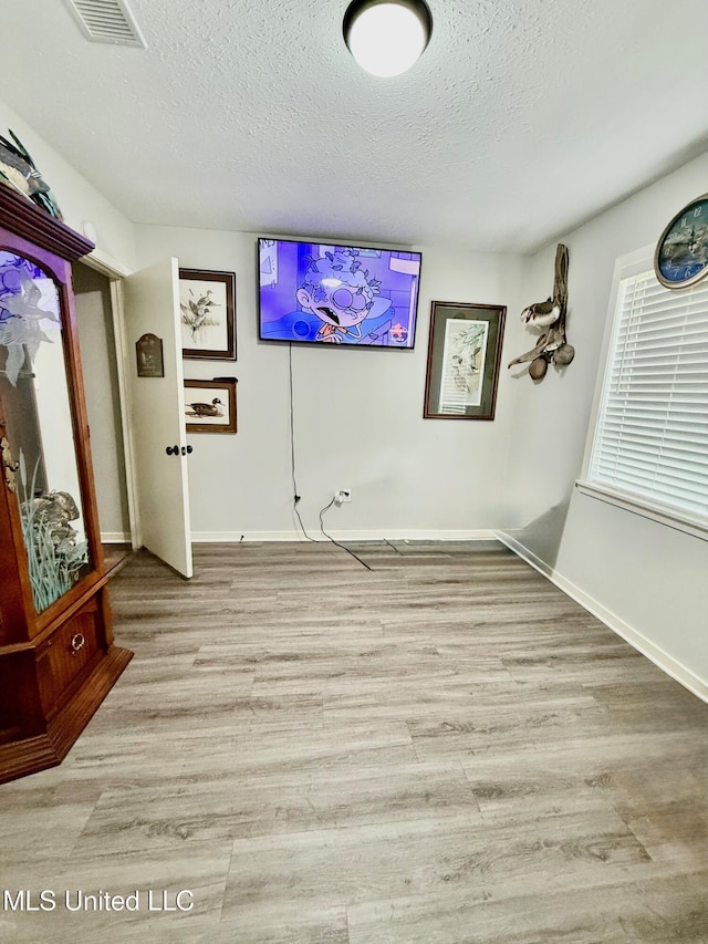 412 Monica Ln, Pearl, MS 39208 - unfurnished dining area with a textured ceiling, light wood-style floors, and baseboards