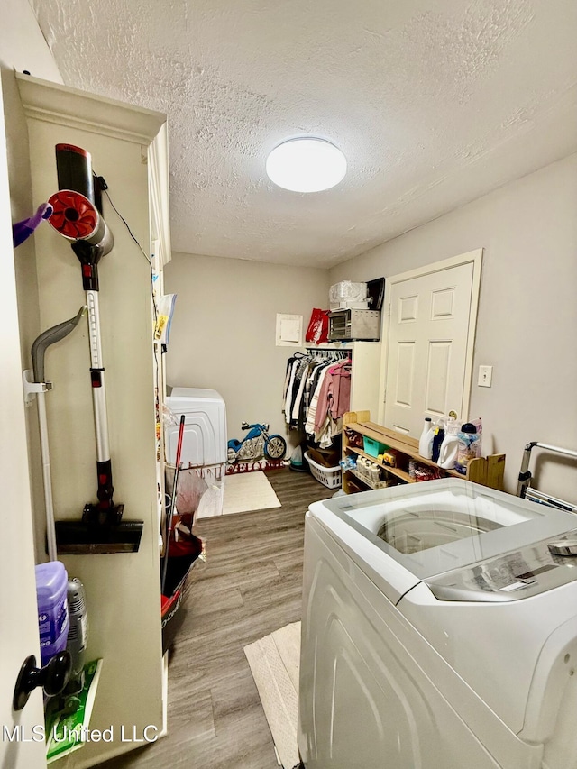 412 Monica Ln, Pearl, MS 39208 - laundry area featuring washing machine and dryer, a textured ceiling, and light wood finished floors