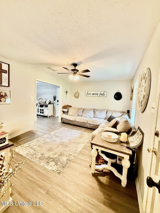 412 Monica Ln, Pearl, MS 39208 - living area with wood finished floors, a textured ceiling, a ceiling fan, and baseboards