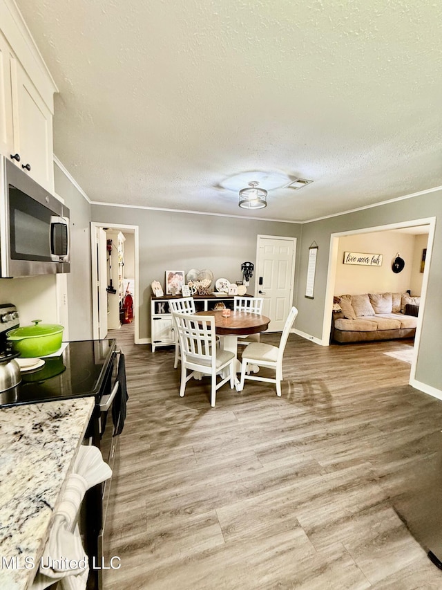 412 Monica Ln, Pearl, MS 39208 - dining space featuring a textured ceiling, baseboards, light wood-type flooring, and crown molding