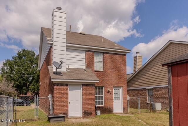 back of house with central AC and a yard