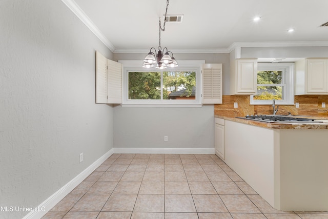 kitchen featuring tasteful backsplash, light tile patterned flooring, pendant lighting, and a notable chandelier