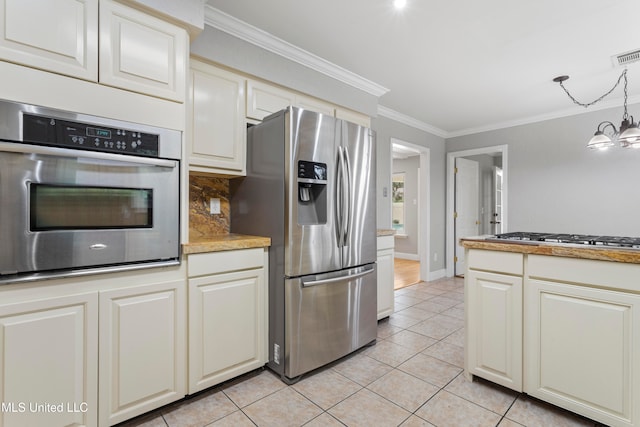 kitchen with a notable chandelier, crown molding, decorative light fixtures, light tile patterned floors, and appliances with stainless steel finishes