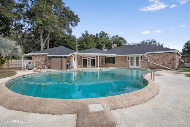 view of swimming pool featuring french doors and a patio