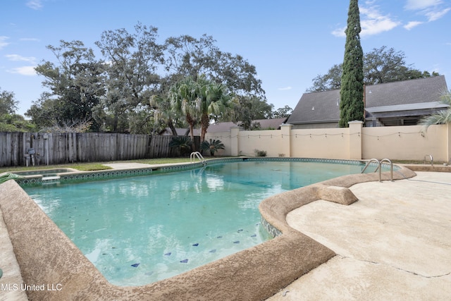 view of swimming pool featuring an in ground hot tub and a patio