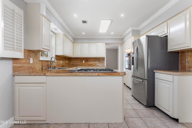 kitchen with kitchen peninsula, sink, white cabinets, and appliances with stainless steel finishes