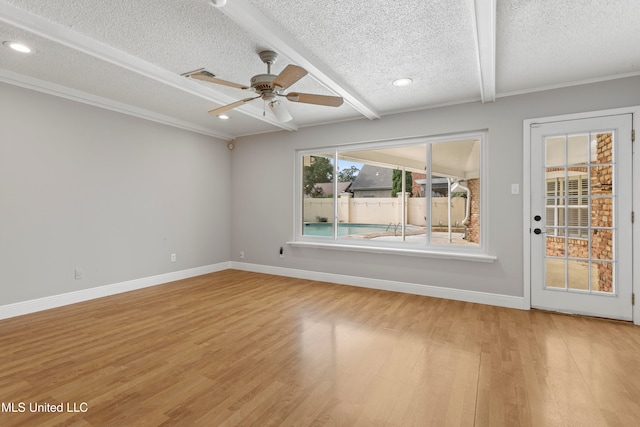 spare room featuring beam ceiling, ceiling fan, hardwood / wood-style floors, and a textured ceiling