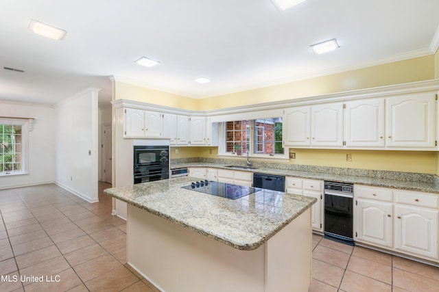 kitchen featuring light stone countertops, a center island, white cabinetry, and black appliances