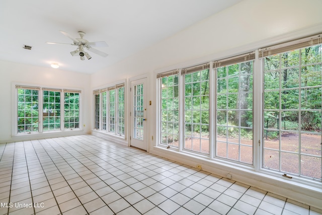 unfurnished sunroom featuring ceiling fan and plenty of natural light