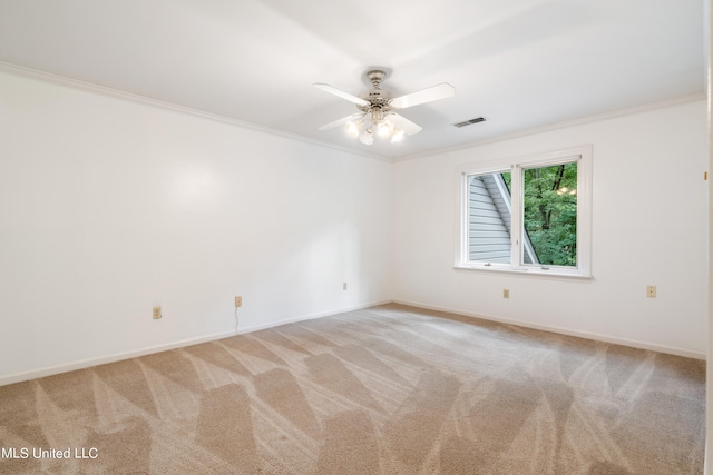 spare room featuring ceiling fan, crown molding, and light carpet