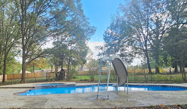 view of pool featuring an in ground hot tub and a water slide