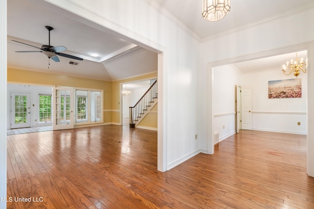 spare room featuring ceiling fan with notable chandelier, vaulted ceiling, crown molding, and light hardwood / wood-style flooring