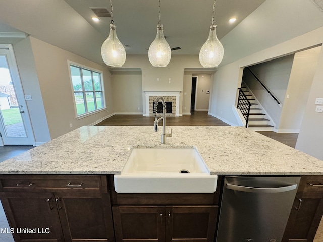 3919 Mcelroy Farms Dr, Olive Branch, MS 38654 - kitchen featuring stainless steel dishwasher, open floor plan, dark brown cabinetry, light stone counters, and a center island with sink