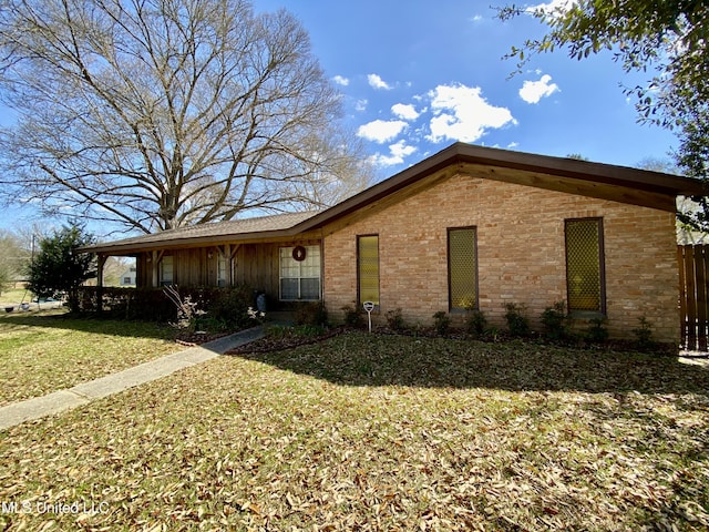 view of side of property featuring a yard and brick siding