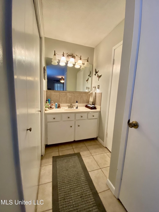 bathroom featuring decorative backsplash, vanity, and tile patterned flooring