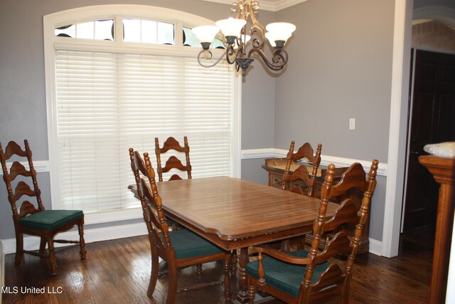 dining space featuring a notable chandelier, dark hardwood / wood-style floors, and crown molding