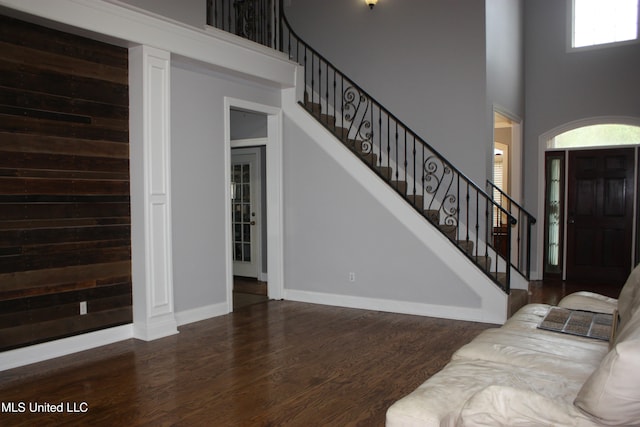 living room with dark hardwood / wood-style floors and a towering ceiling