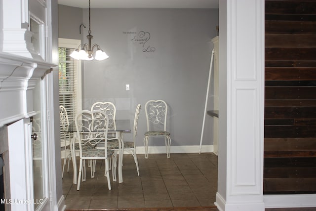 unfurnished dining area featuring a notable chandelier and dark tile patterned flooring