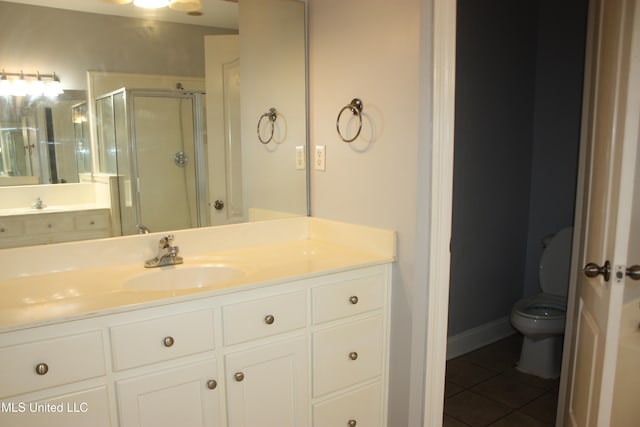 bathroom with walk in shower, vanity, toilet, and tile patterned floors