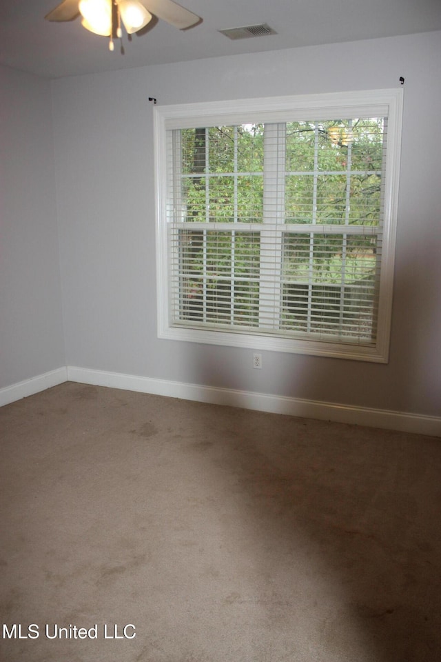 carpeted spare room with ceiling fan