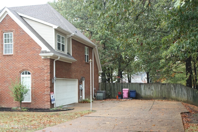 view of home's exterior with a garage and central AC