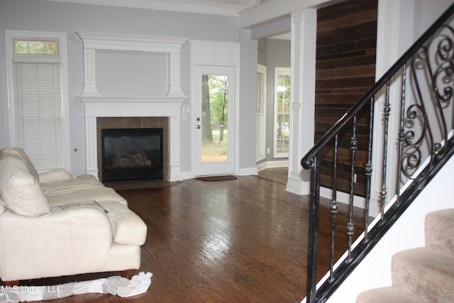 living room featuring dark hardwood / wood-style flooring, ornamental molding, and a fireplace