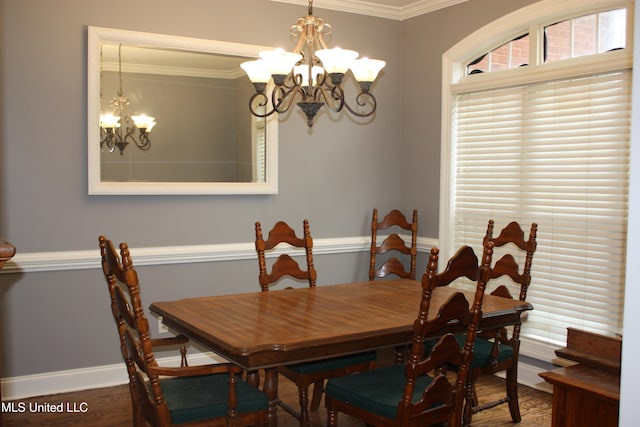 dining area with hardwood / wood-style flooring, a chandelier, and ornamental molding