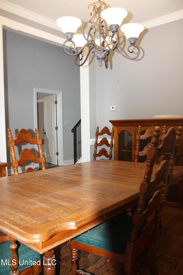 dining area featuring hardwood / wood-style flooring, crown molding, and a notable chandelier