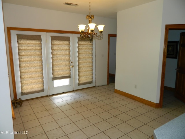 unfurnished room with baseboards, a notable chandelier, visible vents, and light tile patterned floors
