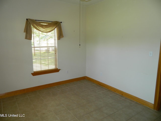 unfurnished room with baseboards