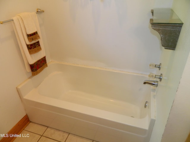 bathroom with a bath, baseboards, and tile patterned flooring