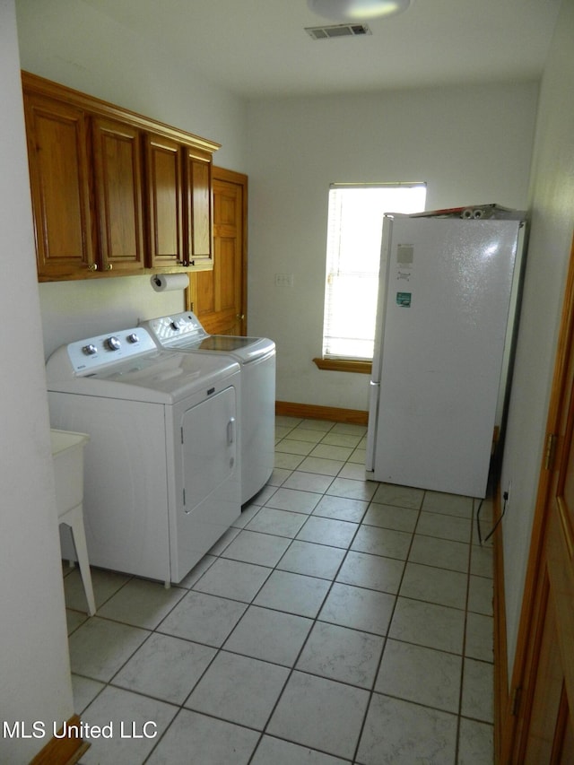 laundry room featuring visible vents, a sink, light tile patterned floors, washer and dryer, and cabinet space