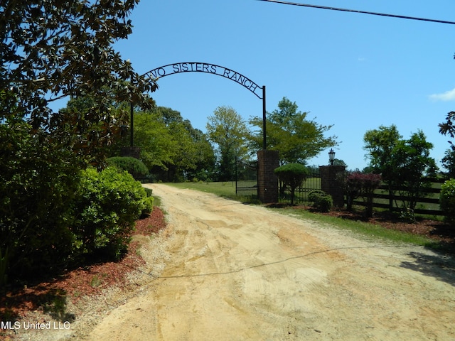 view of street featuring a gated entry and dirt driveway