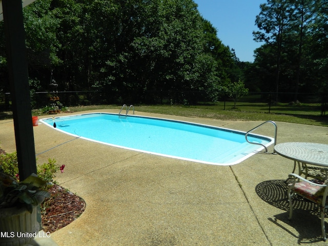 outdoor pool featuring a patio and fence