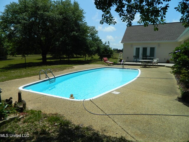 pool with a yard, french doors, a patio area, and fence