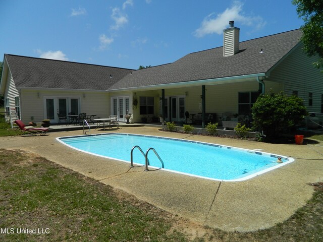 outdoor pool featuring a patio area and french doors