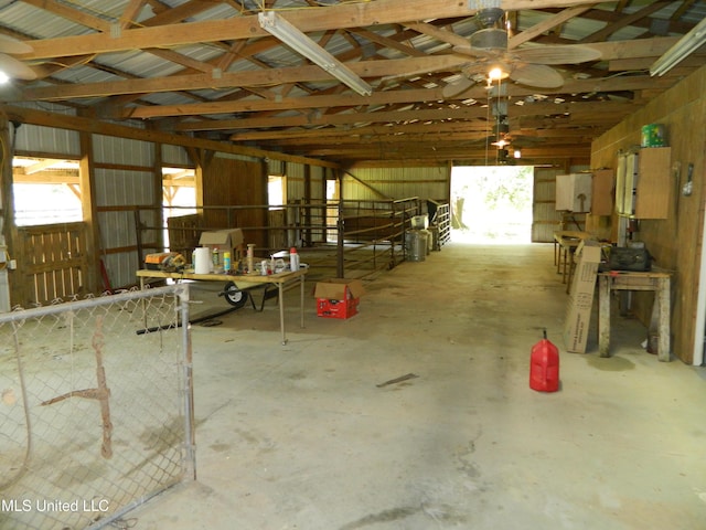 miscellaneous room with vaulted ceiling, a ceiling fan, and unfinished concrete flooring