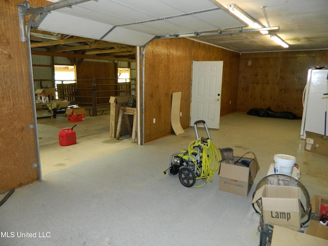 garage with wooden walls and freestanding refrigerator