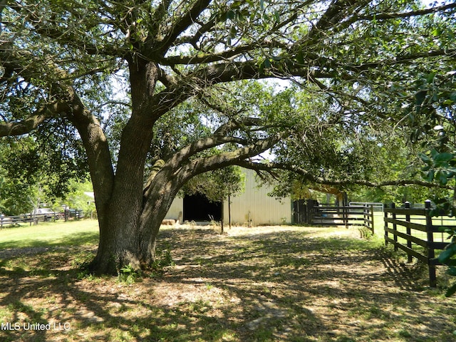 view of yard featuring fence and an outbuilding