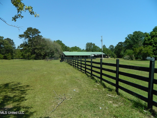 view of yard with fence and a rural view