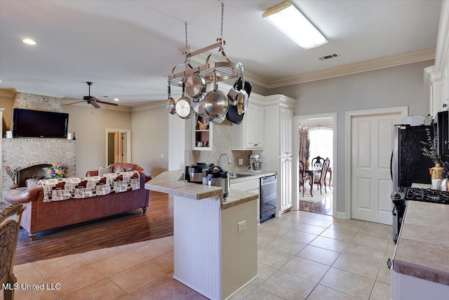 kitchen featuring kitchen peninsula, dishwashing machine, white cabinets, and refrigerator